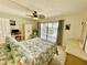 Bright bedroom featuring a ceiling fan, a balcony with water views, and tiled floors at 25188 Marion Ave # F307, Punta Gorda, FL 33950
