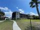 Well-maintained condo building with beautiful landscaping and a pathway leading to the entrance at 25188 Marion Ave # F307, Punta Gorda, FL 33950
