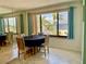 Dining room with water view, a round table, four chairs, and a mirrored wall at 25188 Marion Ave # F307, Punta Gorda, FL 33950