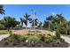 Entrance sign for Emerald Pointe with lush landscaping and palm trees under a clear sky at 25188 Marion Ave # F307, Punta Gorda, FL 33950