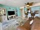 Bright living room featuring a tropical-themed decor, a breakfast bar, and a comfortable brown couch at 25188 Marion Ave # F307, Punta Gorda, FL 33950