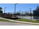 Outdoor tennis courts with a shade structure, lights, benches, and black metal fence for a secure play area at 25188 Marion Ave # F307, Punta Gorda, FL 33950
