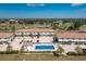 Aerial view of condos shows a pool, parking, landscaping, and a golf course in the distance at 26396 Nadir Rd # 507, Punta Gorda, FL 33983