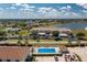 An aerial view of the condo community shows the pool, parking, and building, plus a view of the lake in the distance at 26396 Nadir Rd # 507, Punta Gorda, FL 33983