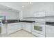 Well-lit kitchen featuring granite countertops, white cabinets, and appliances, plus a breakfast bar overlooking the living area at 26396 Nadir Rd # 507, Punta Gorda, FL 33983