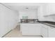 Kitchen featuring granite counters, white cabinets, and a pass-through to the living area, plus a view of the entryway at 26396 Nadir Rd # 507, Punta Gorda, FL 33983