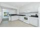 A bright kitchen with white cabinetry, appliances, tile floors and dark countertops at 26396 Nadir Rd # 507, Punta Gorda, FL 33983