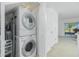 Laundry area features a stacked washer and dryer, additional shelving and access to a rear patio at 26396 Nadir Rd # 507, Punta Gorda, FL 33983