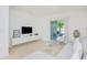 An inviting living room featuring a gray sectional, modern decor, and a view of the screened-in patio through sliding glass doors at 26396 Nadir Rd # 507, Punta Gorda, FL 33983