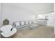 Open-concept living area with modern furnishings, including a sleek sofa, stylish chairs, and a glass coffee table at 26396 Nadir Rd # 507, Punta Gorda, FL 33983