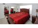 Cozy bedroom features a decorative red bedspread, wooden furniture, and natural light at 4158 Tamiami Trl # G1, Port Charlotte, FL 33952