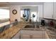 Bright kitchen featuring granite countertops, stainless steel sink, and white cabinetry at 4158 Tamiami Trl # G1, Port Charlotte, FL 33952