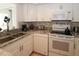 Contemporary kitchen with white cabinets, granite countertops, and modern appliances at 4158 Tamiami Trl # G1, Port Charlotte, FL 33952