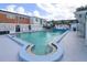 Community swimming pool with ample seating and views of the surrounding apartment buildings on a sunny day at 4158 Tamiami Trl # G1, Port Charlotte, FL 33952