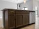 Kitchen island with dark cabinets, hardware, and stainless steel dishwasher at 4425 Lagoon Ter, North Port, FL 34286
