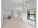 Spacious living area featuring modern light fixture and an open floor plan connecting the kitchen and dining areas at 4425 Lagoon Ter, North Port, FL 34286