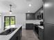 Modern kitchen features gray cabinetry, stainless steel appliances, subway tile backsplash, and a bright quartz countertop at 4453 Lagoon Ter, North Port, FL 34286