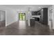 Open living area with tile floors leads to a modern kitchen with gray cabinets and stainless steel appliances at 4453 Lagoon Ter, North Port, FL 34286