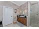 Bathroom featuring a glass enclosed shower, single sink, wood cabinets and neutral tile at 48 Colony Point Dr, Punta Gorda, FL 33950