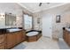 Bathroom featuring double sinks, a standalone tub, and neutral tile flooring at 48 Colony Point Dr, Punta Gorda, FL 33950