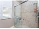 Updated bathroom with glass shower, neutral tile, and white shuttered window providing natural light at 48 Colony Point Dr, Punta Gorda, FL 33950