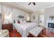 Bedroom features a bench, fireplace and a king bed with decorative pillows at 48 Colony Point Dr, Punta Gorda, FL 33950