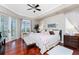 Bedroom with wood floors, a ceiling fan, and French doors leading to a balcony at 48 Colony Point Dr, Punta Gorda, FL 33950
