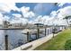 Waterfront property featuring a private boat dock on a sunny day, providing direct access to the serene waters at 48 Colony Point Dr, Punta Gorda, FL 33950