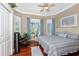 Inviting bedroom features hardwood floors, a cozy recliner and two shuttered windows with stylish blue curtains at 48 Colony Point Dr, Punta Gorda, FL 33950