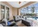 Cozy seating area by the screened-in pool with lush landscaping and water views at 48 Colony Point Dr, Punta Gorda, FL 33950