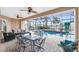 Resort-style screened-in pool area with a dining set, lush greenery, and waterfront views at 48 Colony Point Dr, Punta Gorda, FL 33950