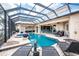 Expansive screened-in pool with outdoor kitchen, seating, dining, and serene waterfront vistas at 48 Colony Point Dr, Punta Gorda, FL 33950