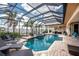Stunning screened-in pool with waterfront views, tanning chairs, and lush landscaping at 48 Colony Point Dr, Punta Gorda, FL 33950