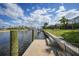 Waterfront dock with boat lift and serene canal views under a cloudy sky at 530 Matares Dr, Punta Gorda, FL 33950