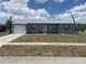 Charming single-story home with a well-maintained lawn, gray exterior and a one car garage at 6728 Thorman Rd, Port Charlotte, FL 33981