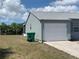 Side view of home featuring a garage, well-maintained exterior, and green trash receptacles at 6728 Thorman Rd, Port Charlotte, FL 33981