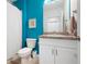 Small half-bath features blue walls, a large mirror, toilet and vanity sink at 7209 W Lenox Cir, Punta Gorda, FL 33950