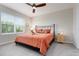 Cozy bedroom features a large window, bedside table, and ceiling fan at 7209 W Lenox Cir, Punta Gorda, FL 33950