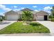 Charming home featuring a well-maintained lawn, double garage, and attractive landscaping with a beautiful palm tree at 7209 W Lenox Cir, Punta Gorda, FL 33950