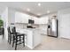 Modern kitchen boasts white cabinetry, stainless steel appliances, and a breakfast bar at 7209 W Lenox Cir, Punta Gorda, FL 33950