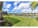 Scenic backyard with lush lawn and tranquil water view, perfect for relaxation at 8725 Amaretto Ave, Sarasota, FL 34238