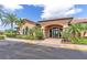 Stunning clubhouse entrance features lush landscaping and an arched entryway, creating an inviting atmosphere at 8725 Amaretto Ave, Sarasota, FL 34238