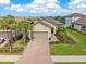 Beautiful single-Gathering home showcasing a lush landscaped yard and inviting brick-paved driveway leading to the two-car garage at 8725 Amaretto Ave, Sarasota, FL 34238