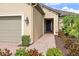 Inviting entryway with a brick walkway, manicured shrubs, and an attached two-car garage at 8725 Amaretto Ave, Sarasota, FL 34238