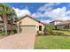 Well-maintained home featuring a two-car garage, manicured landscaping, and a paver driveway at 8725 Amaretto Ave, Sarasota, FL 34238
