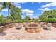 Inviting brick fire pit area offers a cozy outdoor gathering space surrounded by lush landscaping at 8725 Amaretto Ave, Sarasota, FL 34238