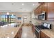 Modern kitchen featuring granite countertops, stainless steel appliances, and views of the water with a casual dining area at 8725 Amaretto Ave, Sarasota, FL 34238