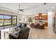 Open-concept living room seamlessly connected to the kitchen, featuring tile flooring and large windows with serene lake views at 8725 Amaretto Ave, Sarasota, FL 34238