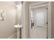 Powder room with pedestal sink and view of the laundry room at 8725 Amaretto Ave, Sarasota, FL 34238