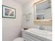 Compact bathroom featuring a sink, toilet, decorative wall art, and a well-lit mirror at 114 Mcgregor St, Punta Gorda, FL 33950